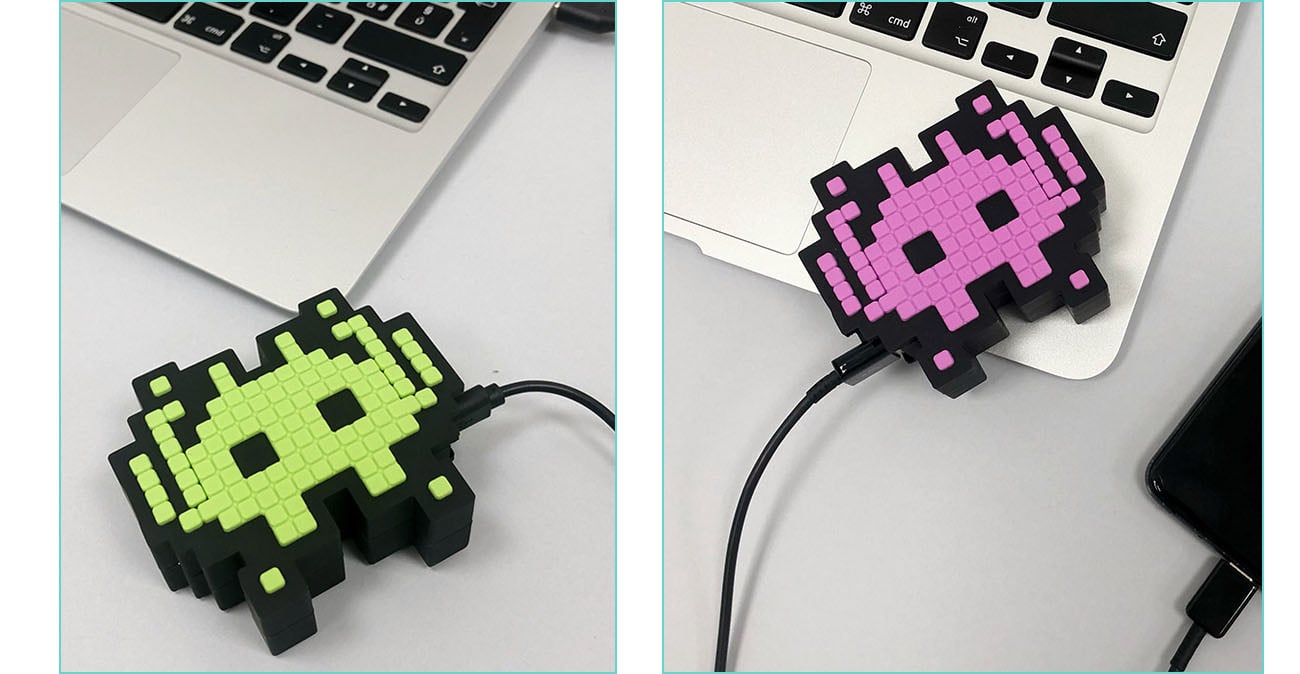 Two pictures of Moji Power Bank Invaders with one showing the green side and the other showing the pink side